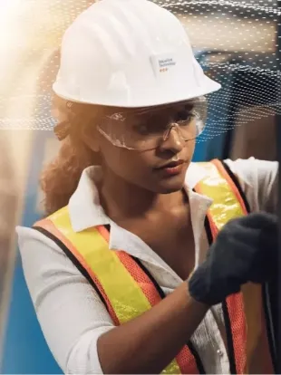 Jeune femme sur un chantier avec casque et gilet de sécurité